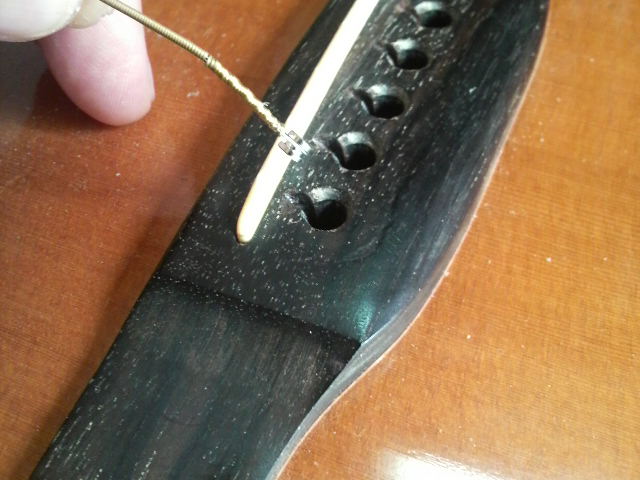 弦を穴から抜く